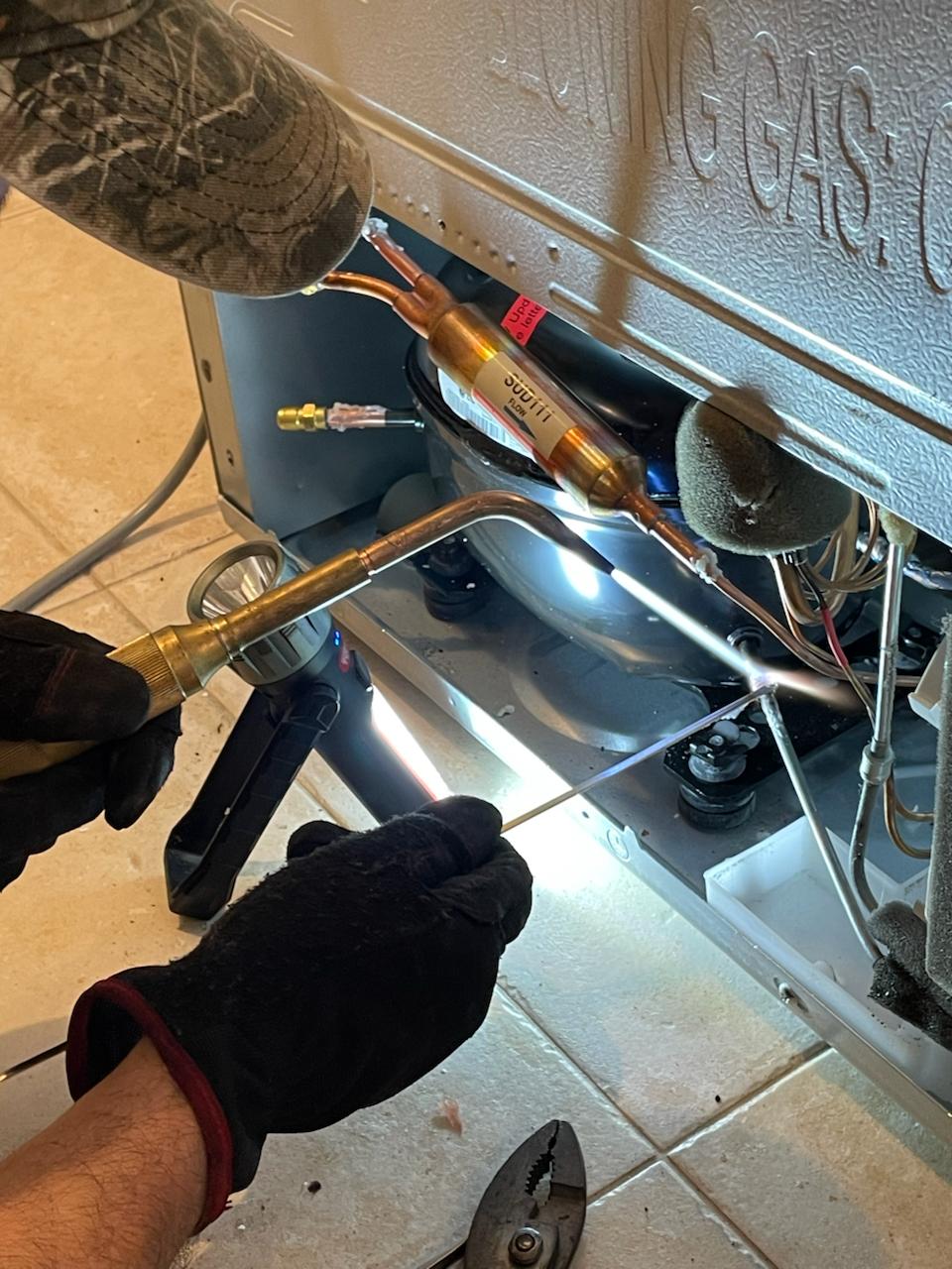 Close-up appliance cooling-system service work
