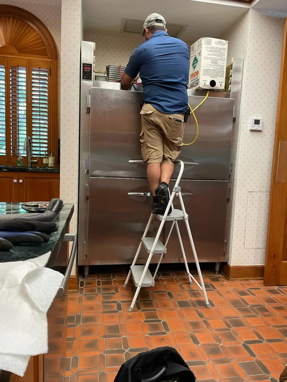 Technician servicing a residential refrigerator