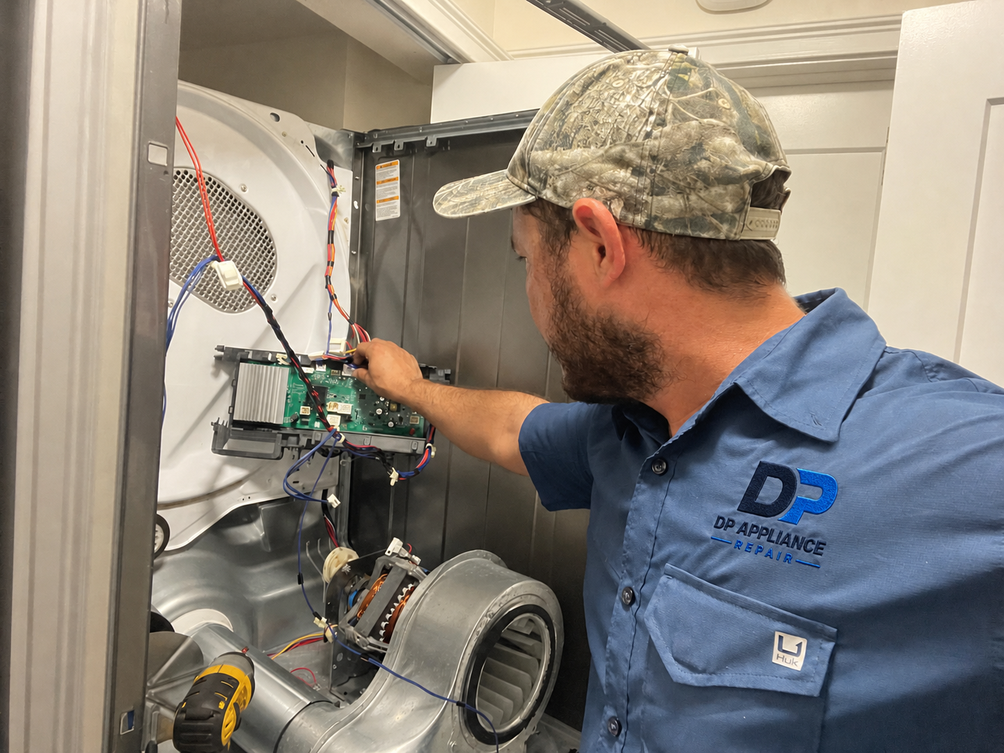 DP Appliance Repair technician servicing a dryer