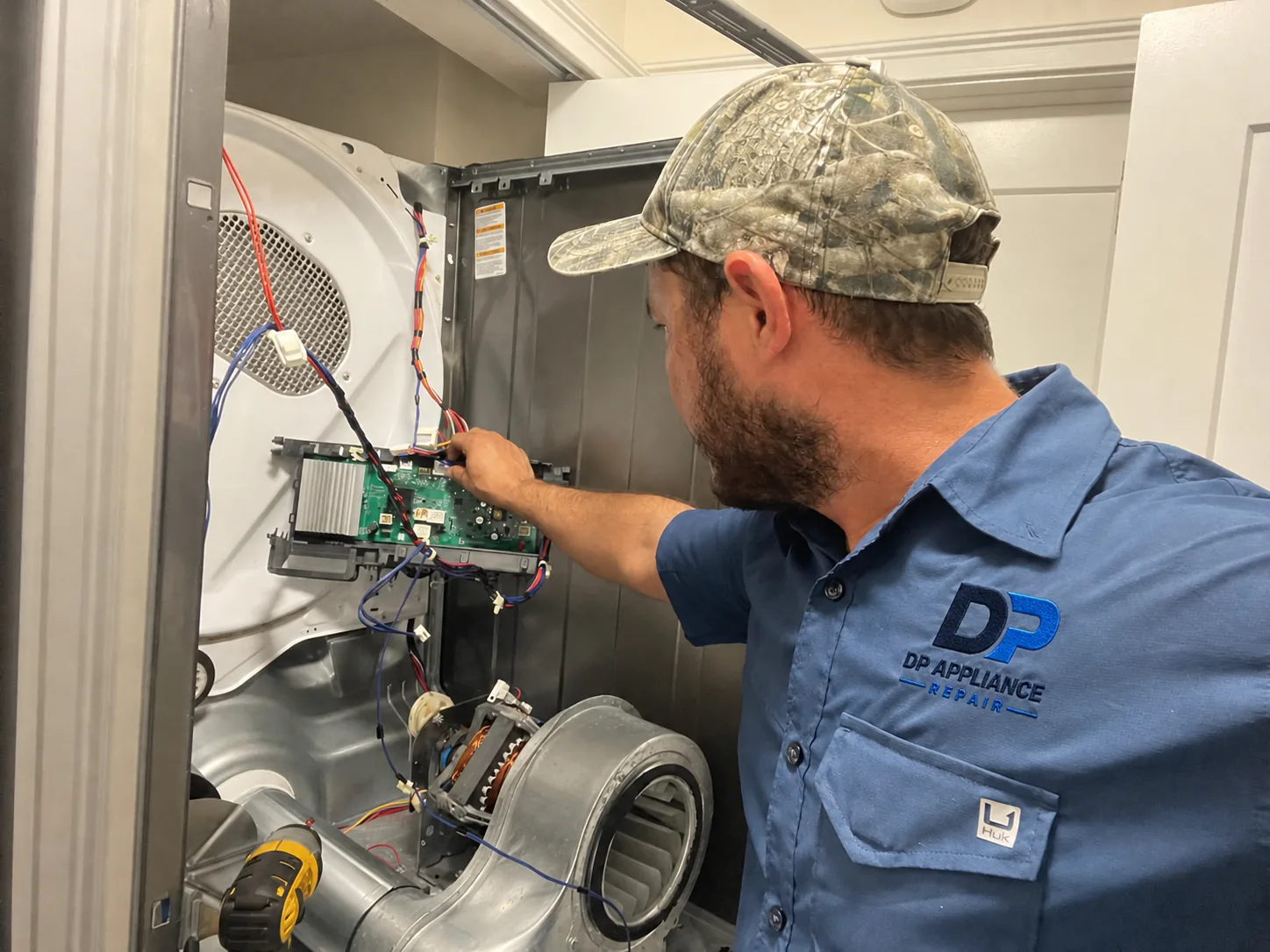 DP Appliance Repair technician diagnosing a dryer