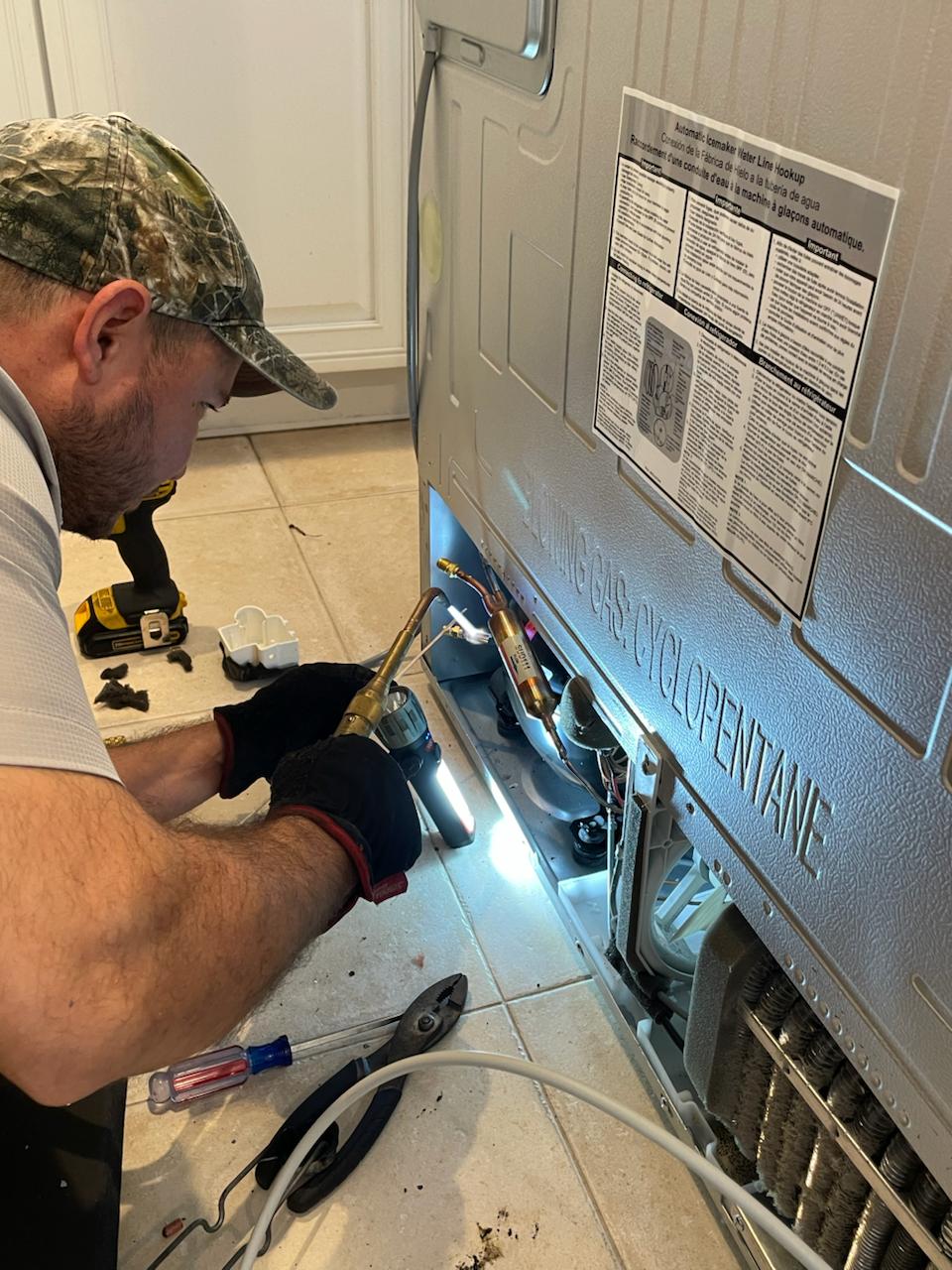 Technician servicing refrigerator components